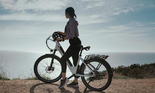 a woman standing next to a bicycle